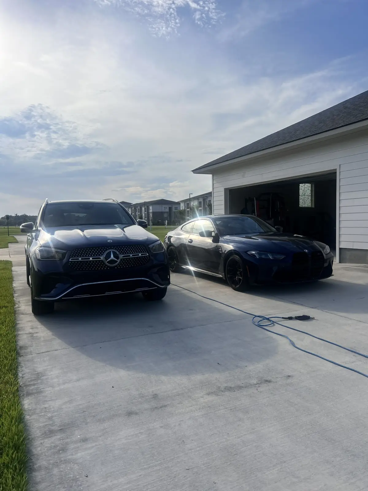 Freshly detailed Mercedes-Benz GLE and BMW M4 drying in a Gonzales, Louisiana driveway after a full exterior detail