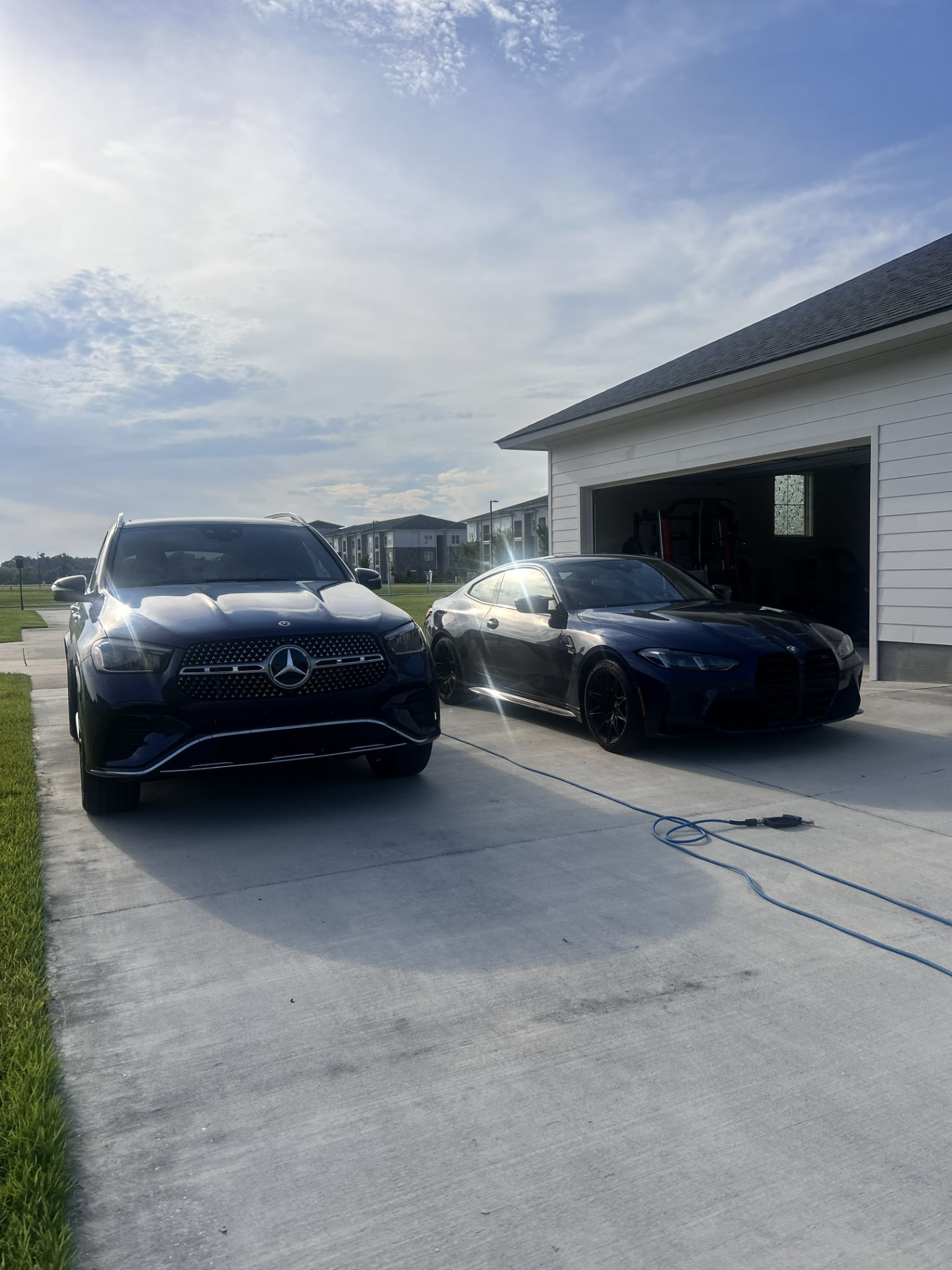 Freshly detailed Mercedes-Benz GLE and BMW M4 drying in a Gonzales, Louisiana driveway after a full exterior detail